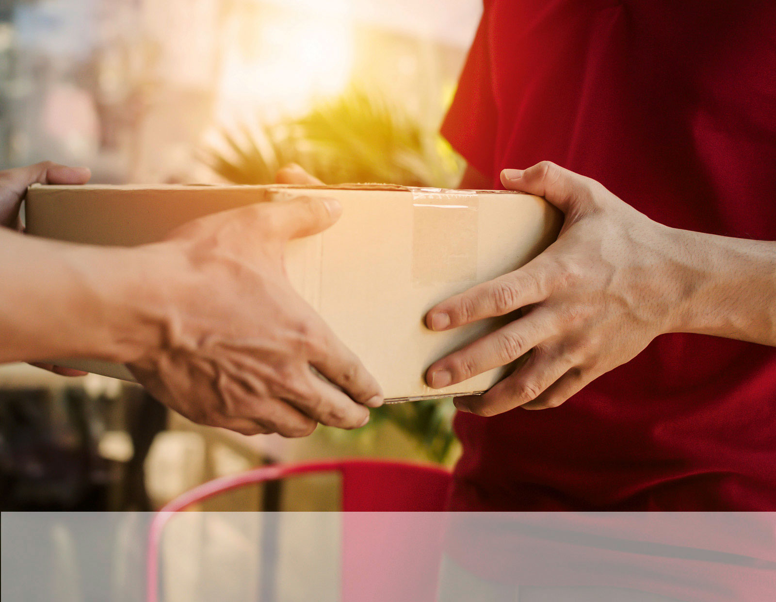 Ein Paketzusteller übergibt ein Paket an den Empfänger.